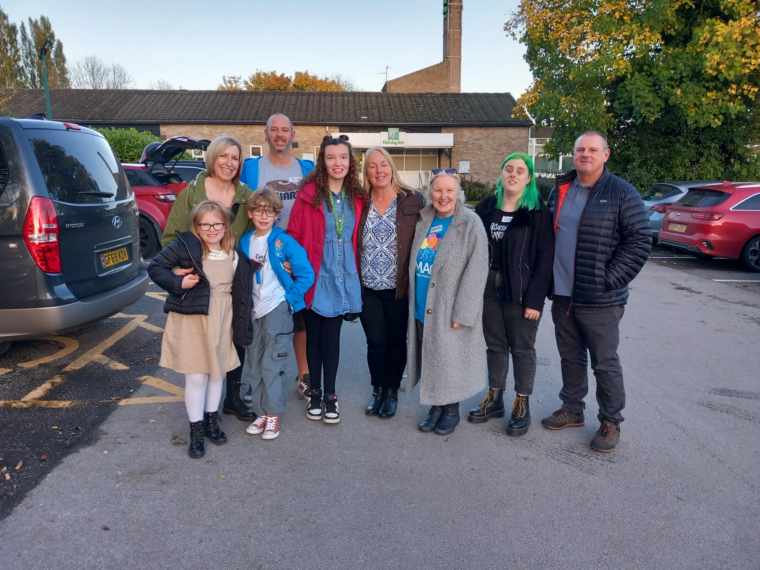 Decorative image to accompany blog post on the Chesterton House Foundation grant to MACS. Image of nine people standing in car park.