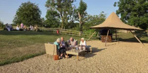 A photo of guests enjoying the sunshine on the grassed area at Prestwold Hall Barns for our summer BBQ.