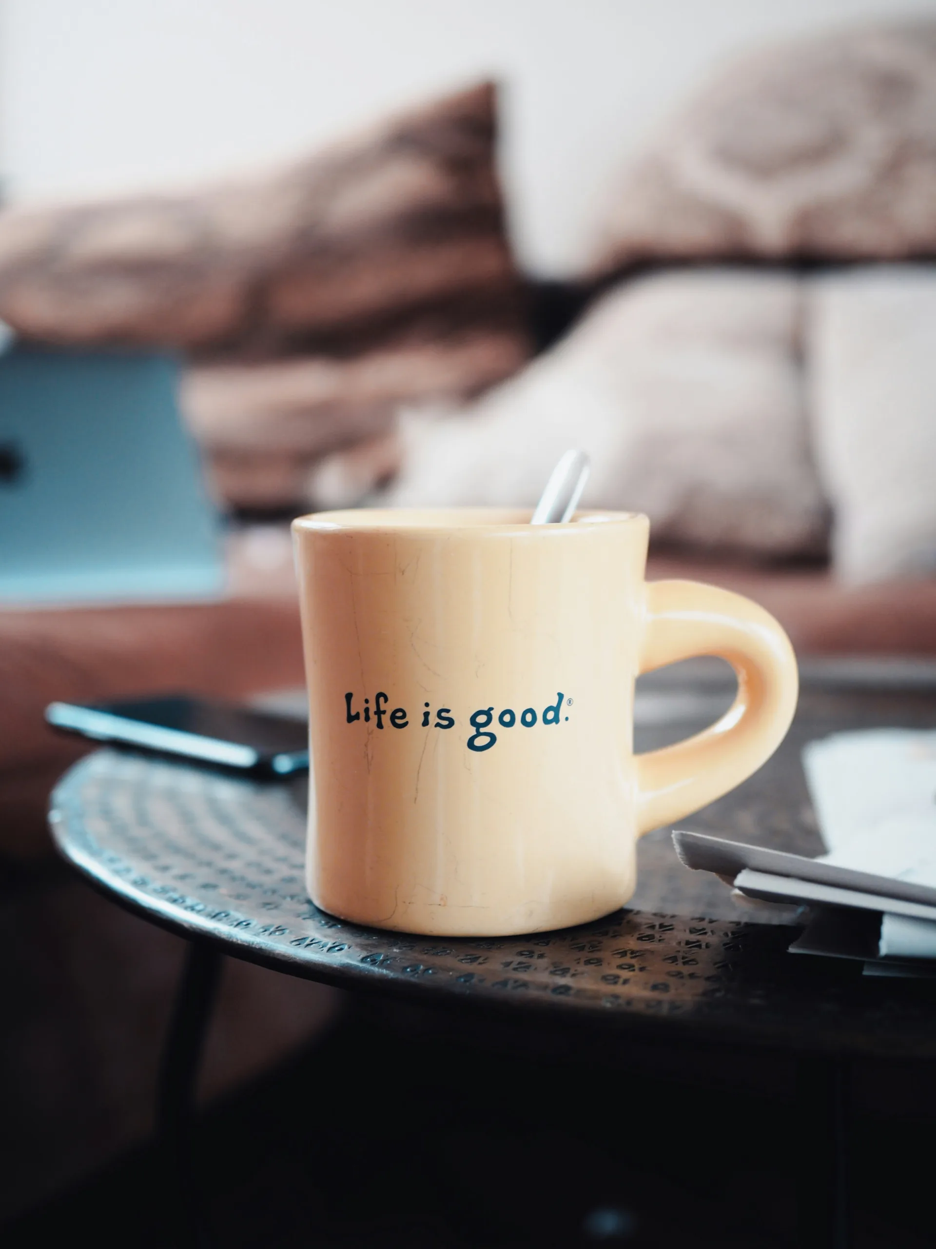 decorative image to accompany blog post on living a great life and financial security. photo of a mug with the words life is good on it sitting on a plate.